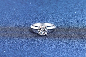 Macro view of a classic four-prong silver ring featuring a brilliant round cut gemstone