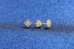 Detailed view of S925 silver four-leaf clover moissanite studs on dark background