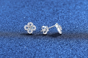 Detail view of silver four-leaf clover moissanite earrings with sparkling cubic zirconia