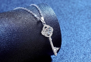 Macro view of S925 silver four-leaf clover key necklace with brilliant moissanite stone