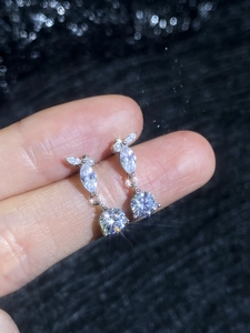 Macro view of teardrop moissanite earrings with sparkling round and marquise-cut stones