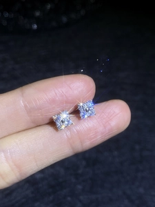 Macro detail of S925 sterling silver clover earrings with sparkling moissanite stones