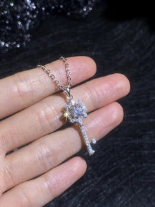 Detail of S925 sterling silver key pendant with octagram star and sparkling moissanite