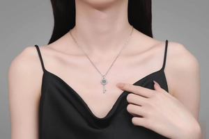 Detailed close-up of a sterling silver eight-pointed star key pendant with moissanite