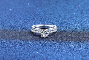Close-up of S925 sterling silver moissanite bridal set with six-prong main stone and eternity band
