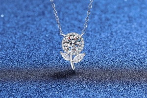 Vue macro du pendentif cerise en argent avec moissanite sur fond bleu scintillant