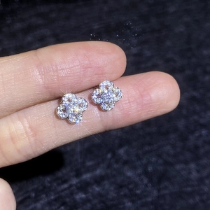 Sparkling moissanite clover stud earrings in S925 sterling silver held for detail