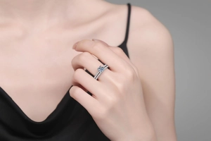 Close-up of stacked S925 sterling silver rings with round moissanite on a model