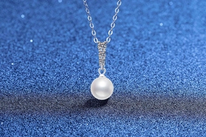 Détail d'un collier en argent S925 avec perle blanche et quatre pierres en moissanite