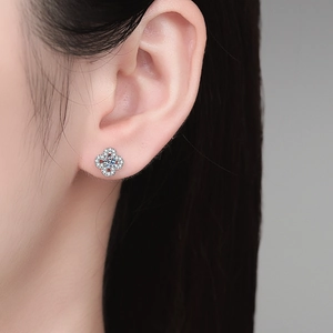 Elegant silver four-leaf clover stud earrings with moissanite center stone and halo diamonds