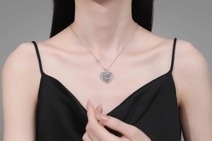 Model wearing 3-carat heart shaped silver necklace with brilliant round moissanite stone
