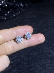 Macro shot of S925 sterling silver moissanite snowflake stud earrings held in hand