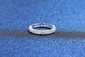 Detailed view of S925 sterling silver moissanite ring with pavé diamonds and circular cut stones