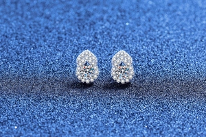 Macro view of sterling silver gourd earrings with moissanite center stone and halo diamonds