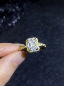 Makroaufnahme von Smaragdschliff Moissanit Ring mit 18K Vergoldung und Pavé-Diamantbesatz
