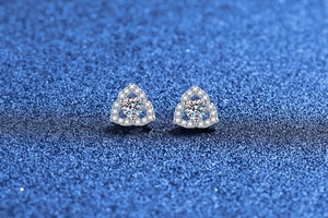 Macro shot of 925 silver flower stud earrings with sparkling moissanite on dark background