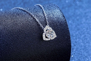 Macro detail of silver heart pendant with large brilliant-cut moissanite and star background