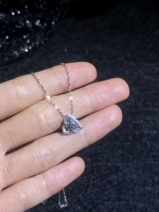 Macro shot of s925 silver clover heart pendant with moissanite on black background