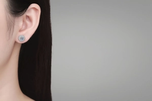 Close-up of S925 sterling silver halo moissanite stud earrings on a model's ear