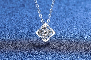 Macro shot of S925 silver four-leaf clover pendant with moissanite on blue starry backdrop
