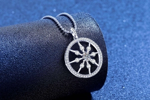 Macro detail of S925 silver compass pendant with moissanite center on leather stand