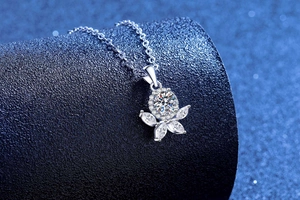 Macro detail of S925 sterling silver flower pendant with moissanite center stone on a stand