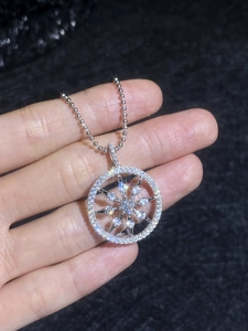 Macro shot of silver compass moissanite pendant featuring sparkling celestial star design