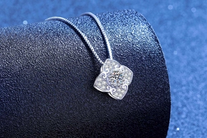 Macro shot of clover shaped S925 silver pendant with sparkling moissanite diamonds