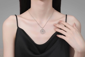 Detail shot of a moissanite compass pendant necklace worn on a black silk garment