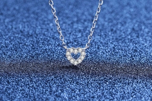 Dettaglio macro del ciondolo a cuore d'argento con zirconi pavé su catena classica