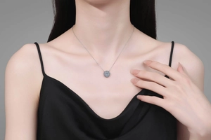 Close-up of s925 silver sunflower pendant with blue moissanite on a female model