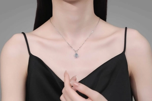 Close-up of a Moissanite flower pendant necklace on a model wearing black silk