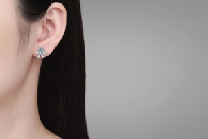 Detail shot of Moissanite flower stud earrings in S925 sterling silver on a female ear