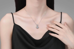 Close-up of S925 silver heart and snowflake pendant necklace with moissanite on model
