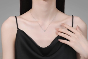 Elegante primo piano di un delicato ciondolo a cuore in moissanite indossato da una modella