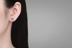 Close-up of sparkling moissanite flower stud earrings in S925 silver on model's ear