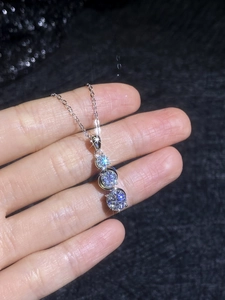 Macro detail of S925 sterling silver necklace with three graduated moissanite pendants