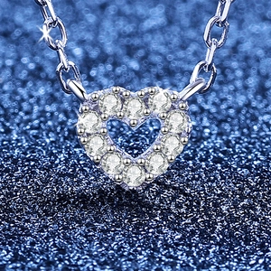 Collana con pendente a cuore in moissanite scintillante su sfondo blu stellato