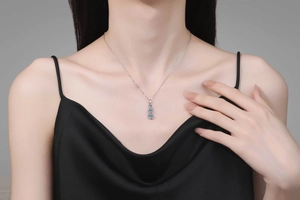 Detail of S925 sterling silver necklace with three vertical blue moissanite stones on model
