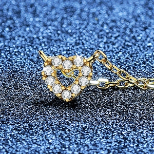 Elegante collana con ciondolo a cuore dorato con pietre bianche e design traforato