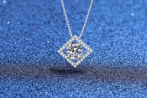 Macro di una collana in argento 925 con pendente in moissanite da 1ct su sfondo blu