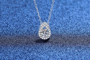 Vue macro du pendentif gourde en argent avec moissanite étincelante sur fond bleu chic
