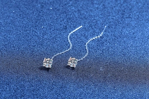Macro detail of S925 sterling silver ear threads with four-prong moissanite stones