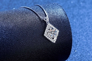 Close-up of geometric S925 silver pendant featuring a central round moissanite diamond