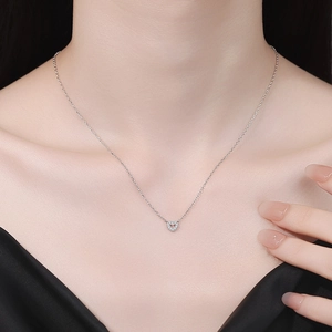 Elegante collana a cuore in moissanite argento indossata da una modella per un look dolce