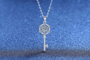 Detailed close-up of a silver key pendant with a hexagon snowflake moissanite head