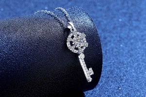 Detailed close-up of a silver key pendant encrusted with sparkling moissanite stones