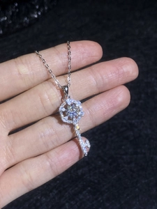 Close-up of a 925 silver key pendant with floral moissanite head and pave diamond setting