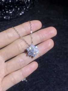 Detailed close-up of S925 silver snowflake pendant necklace with sparkling moissanite stones