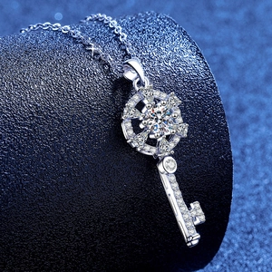 Sparkling Moissanite key pendant necklace in 925 sterling silver on a navy blue background
